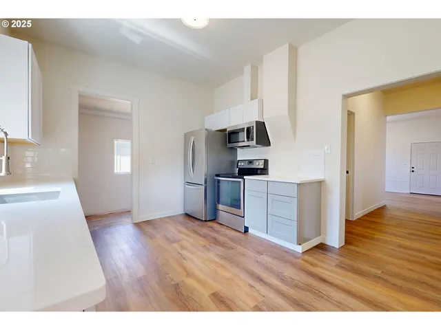 a kitchen with wooden floors and appliances