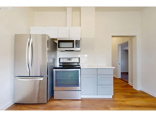 a kitchen with a refrigerator cabinets and wooden floor