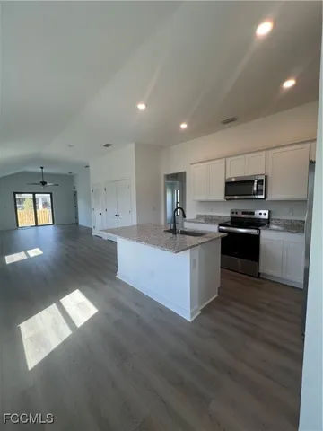 a large kitchen with stainless steel appliances a large counter top and a stove