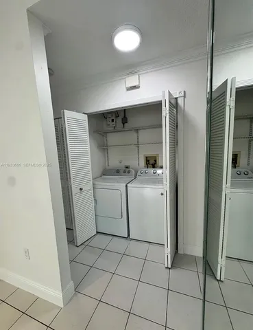 a utility room with cabinets washer and dryer