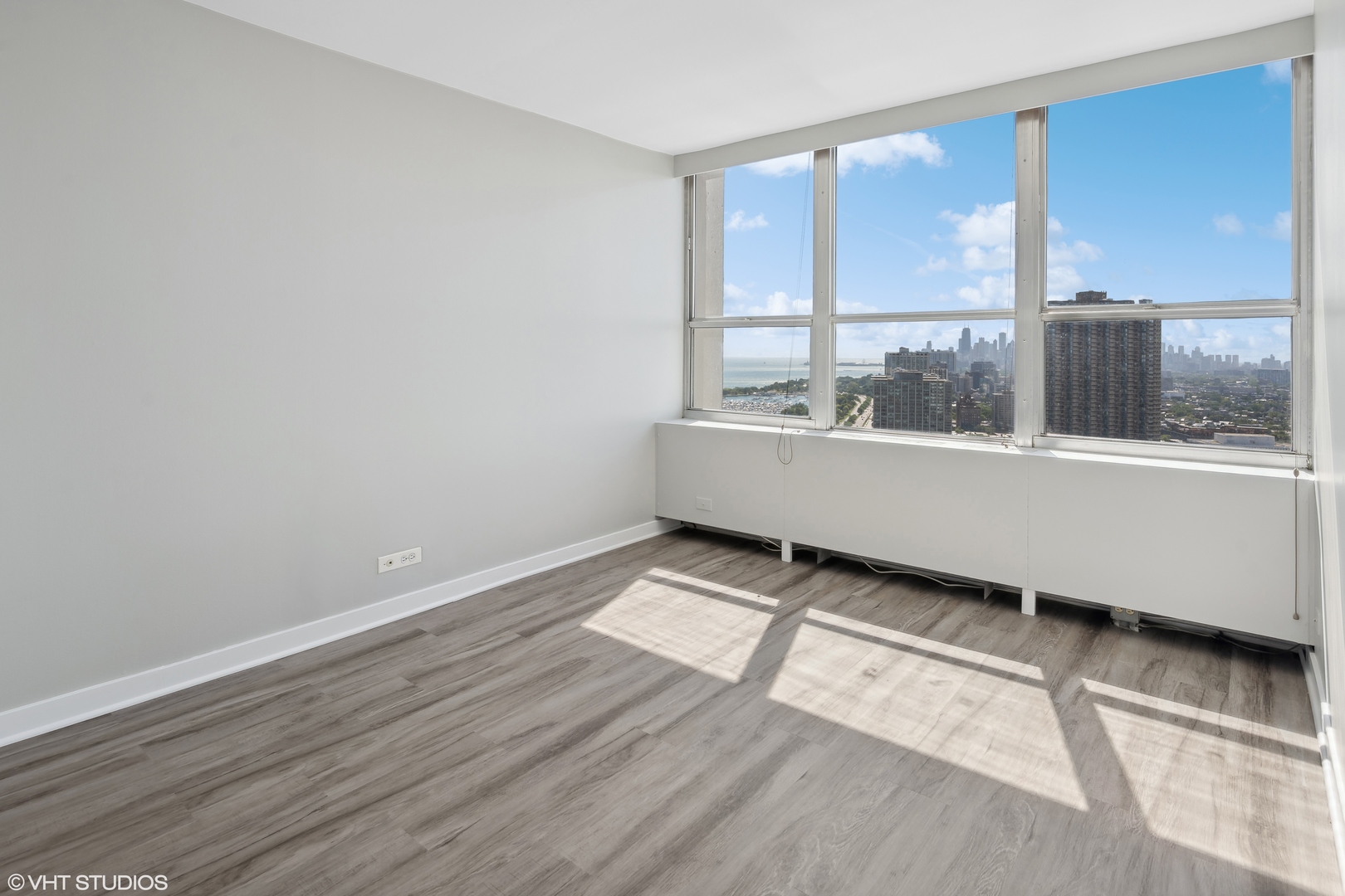655 West Irving Park Road, Unit 3707 Chicago, IL 60613 - Photo 2 of 13 an empty room with wooden floor and windows