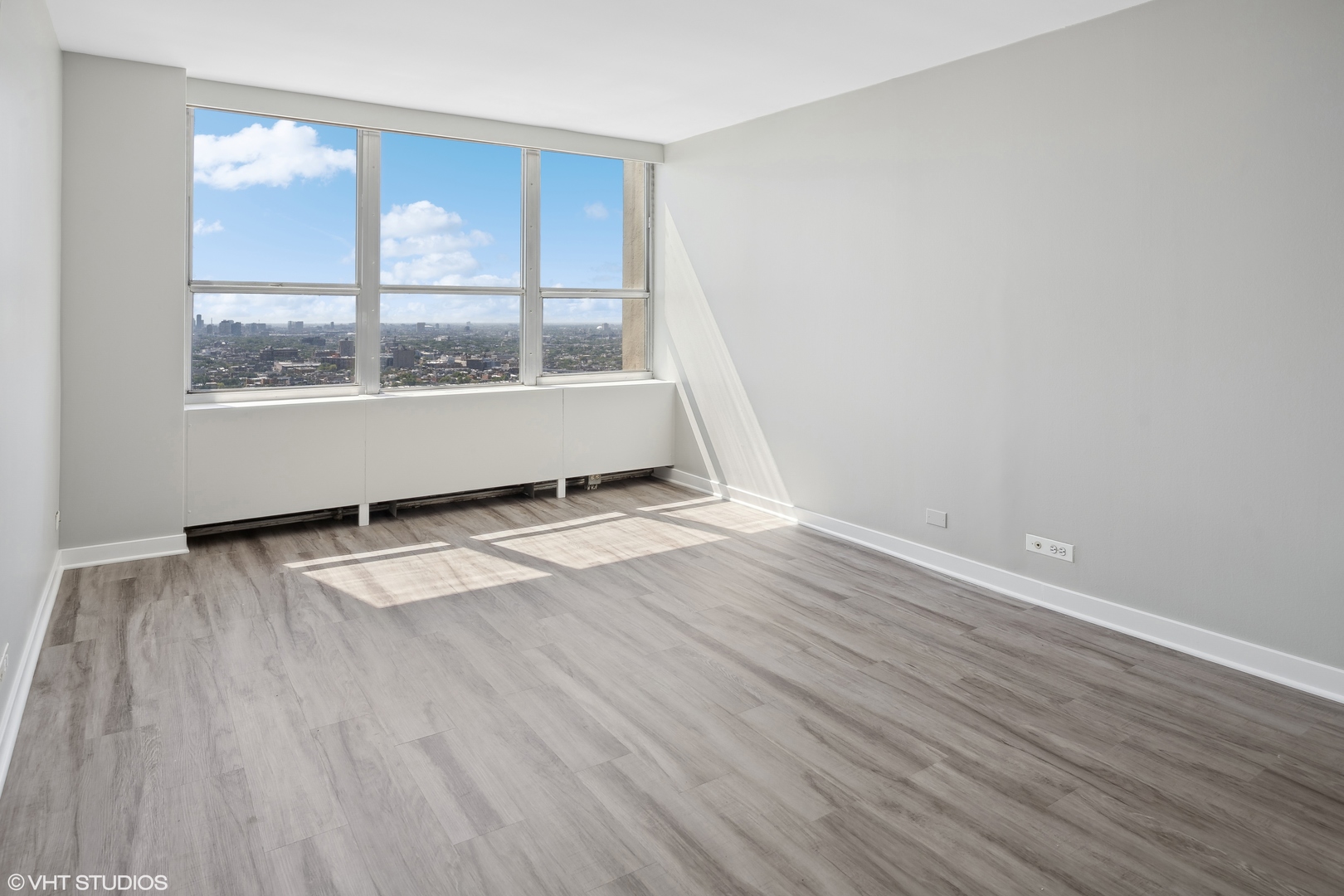 655 West Irving Park Road, Unit 3707 Chicago, IL 60613 - Photo 5 of 13 an empty room with wooden floor and windows