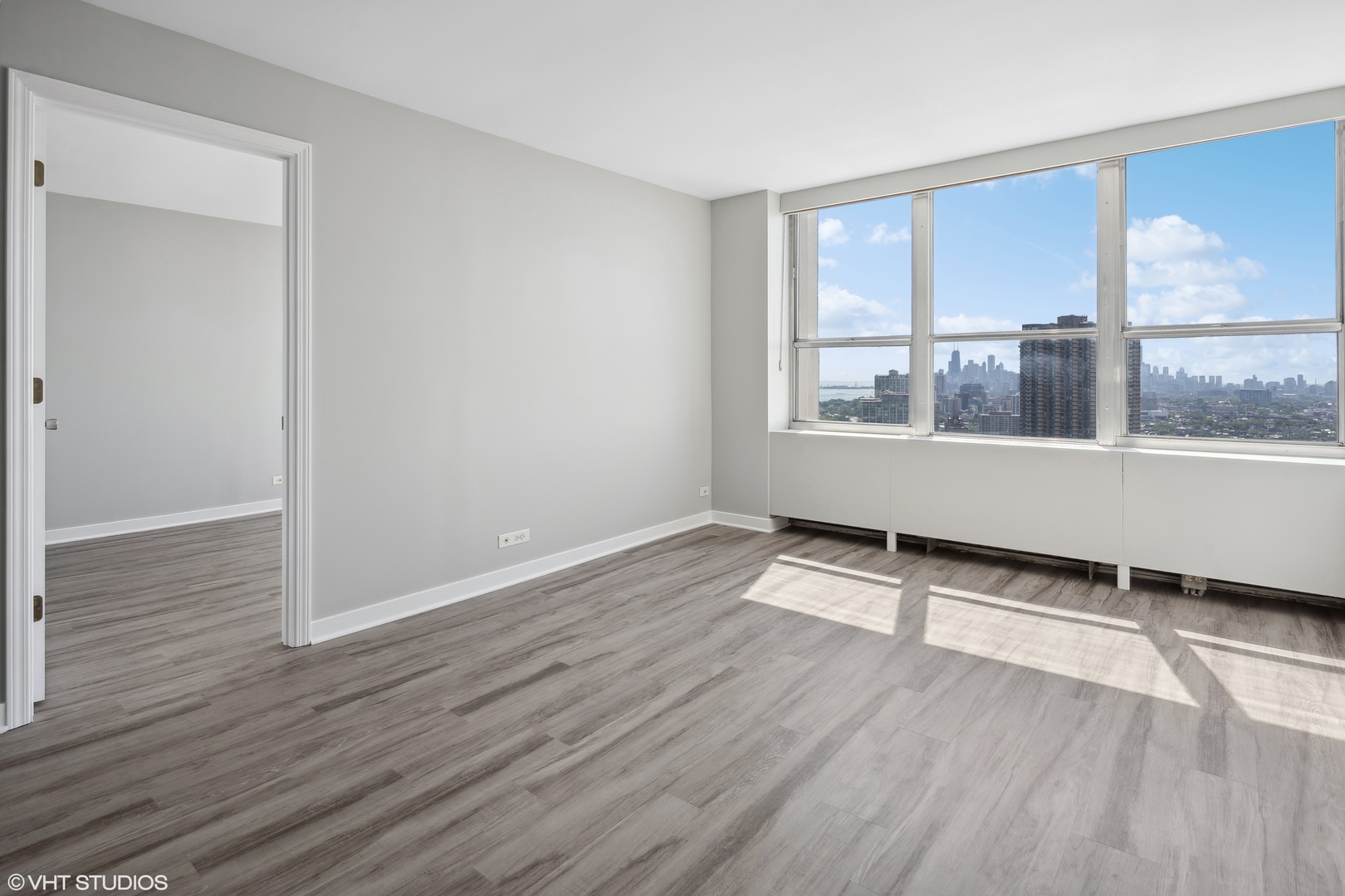 655 West Irving Park Road, Unit 3707 Chicago, IL 60613 - Photo 6 of 13 an empty room with wooden floor and windows