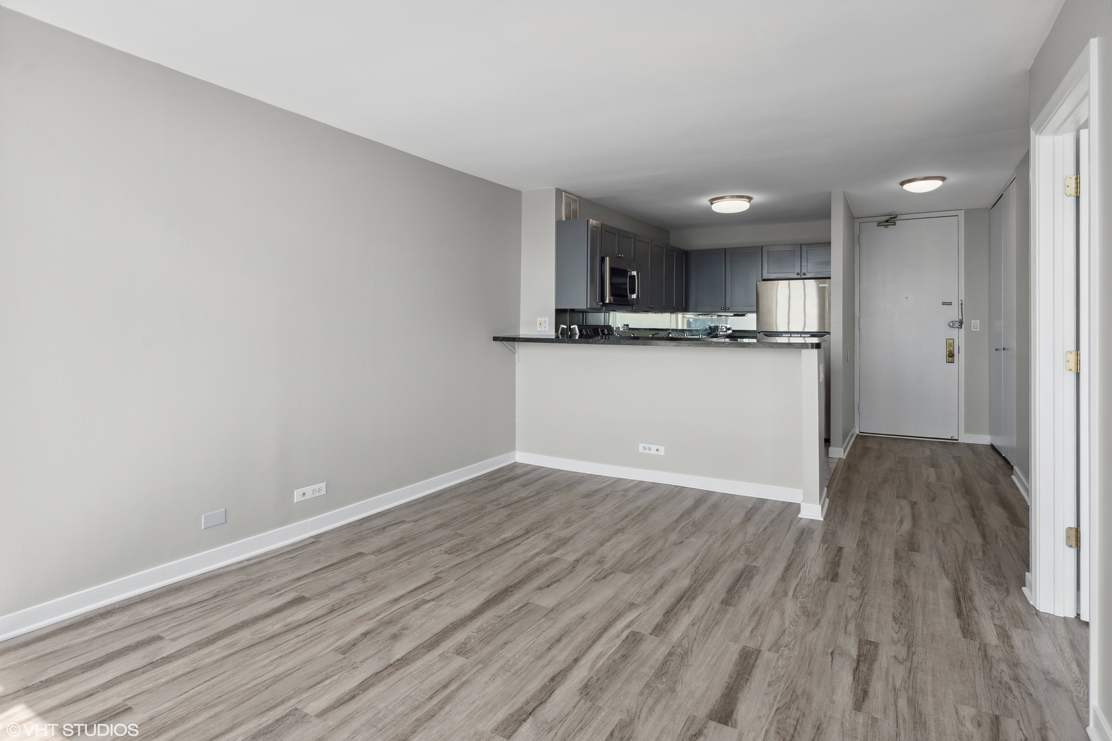655 West Irving Park Road, Unit 3707 Chicago, IL 60613 - Photo 8 of 13 a view of kitchen and empty room with wooden floor