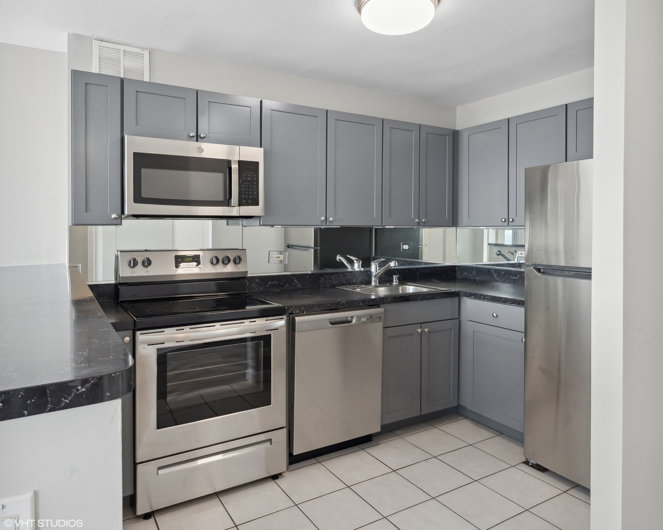 655 West Irving Park Road, Unit 3707 Chicago, IL 60613 - Photo 10 of 13 a kitchen with stainless steel appliances granite countertop a stove microwave and refrigerator