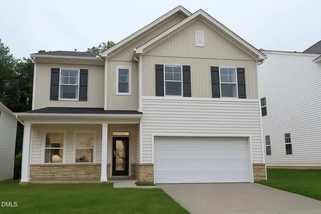 a view of a white house with a small yard and plants