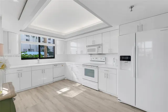 a kitchen with white cabinets and white appliances