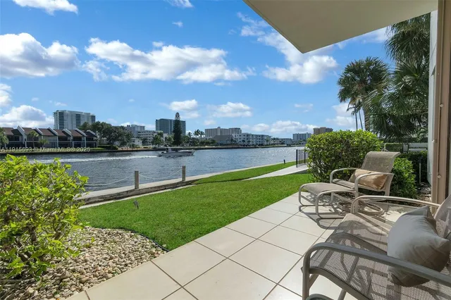 a view of a swimming pool and lounge chairs in back yard of the house