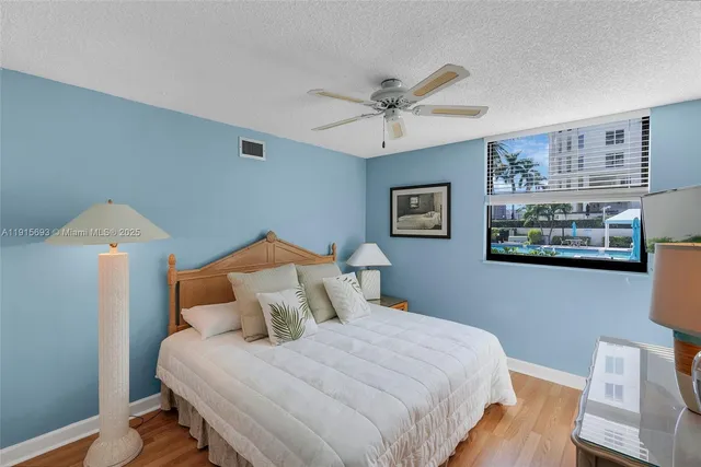 a bedroom with a bed and a lamp on dresser