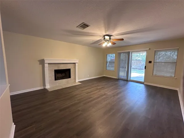 a view of an empty room with a fireplace and a window