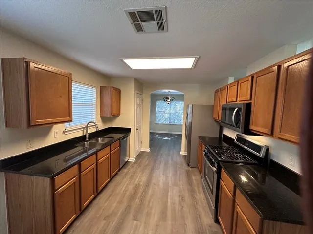 a kitchen with stainless steel appliances a sink dishwasher stove and oven