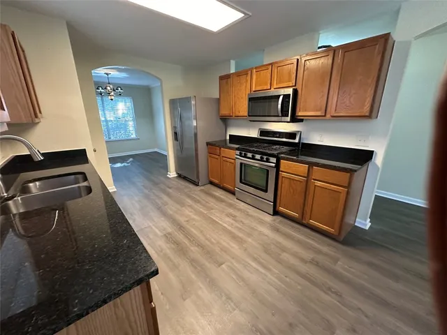 a kitchen with stainless steel appliances granite countertop a stove a sink and a microwave