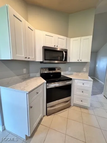 a kitchen with granite countertop a stove a microwave and cabinets