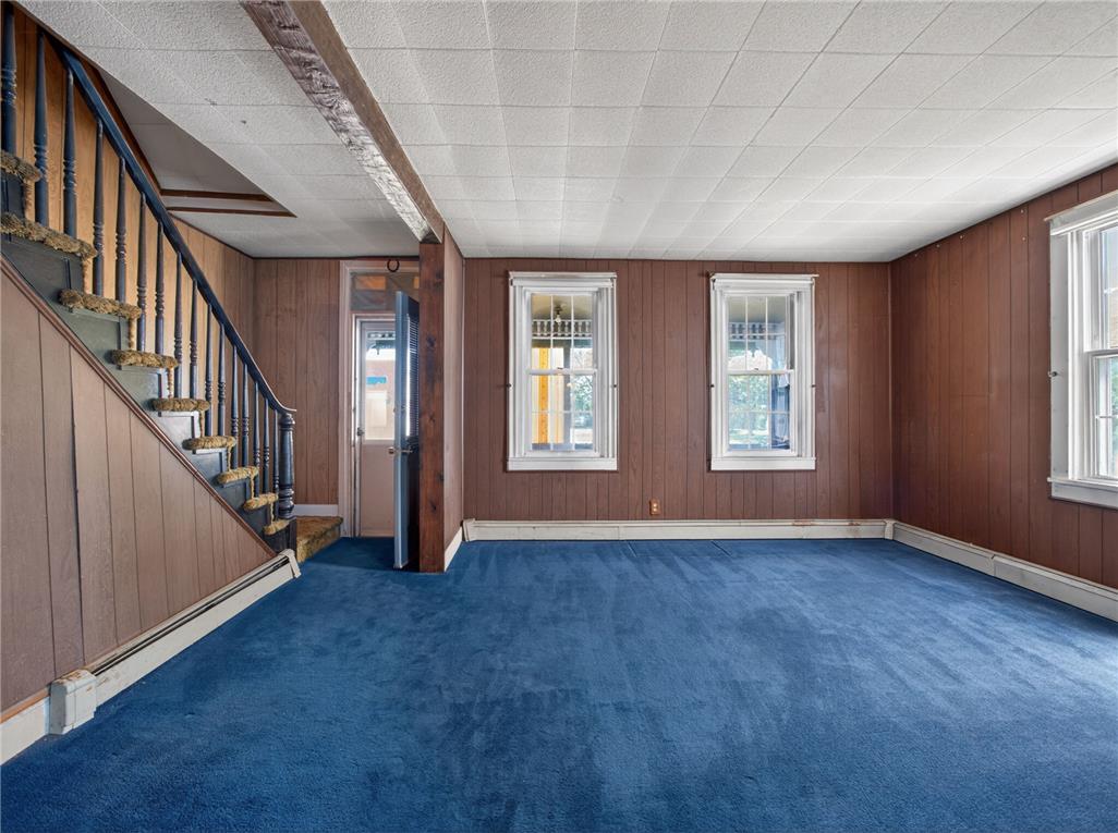 15845 Kutztown Road Mertztown, PA 19539 - Photo 3 of 24 A well-lit living space with a classic staircase and warm wood paneling.