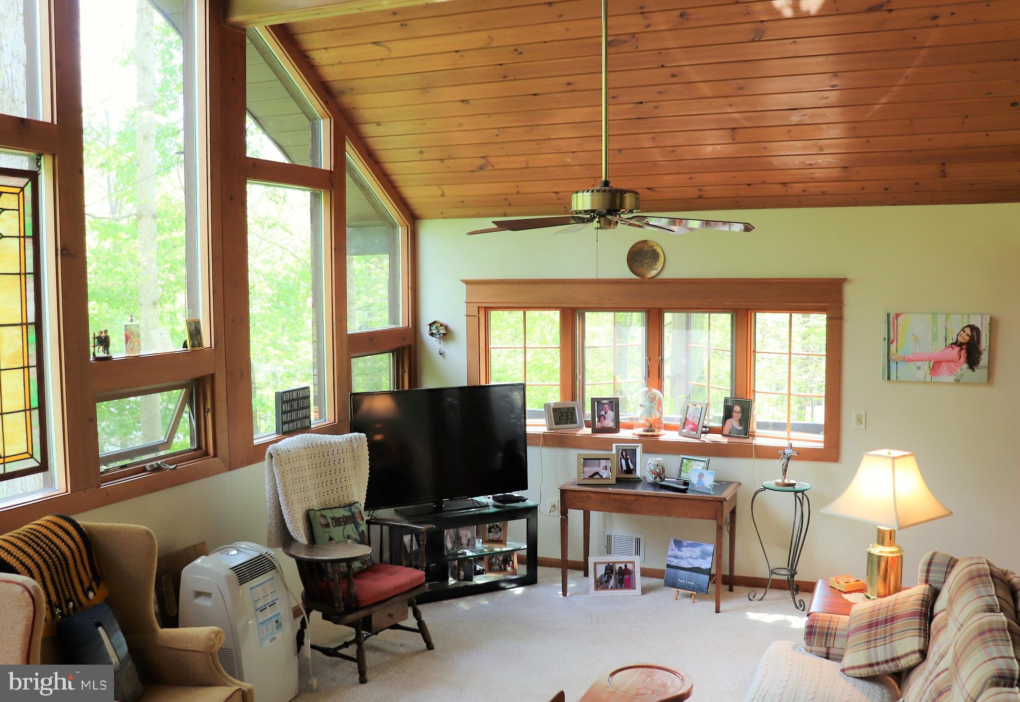 168 Cherry Tree Road Addison, PA 15411 - Photo 14 of 42 a living room with furniture a flat screen tv and a floor to ceiling window