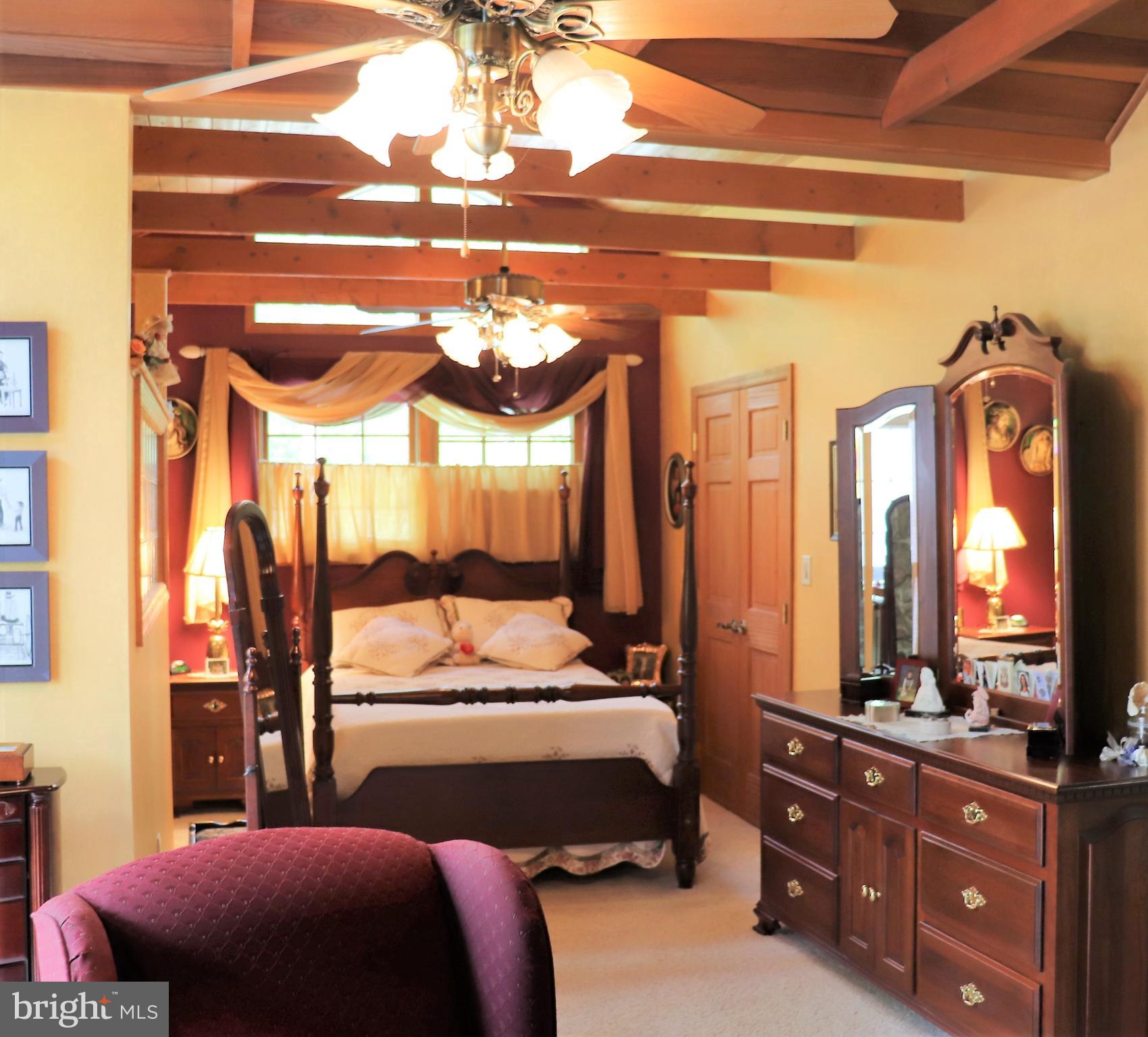 168 Cherry Tree Road Addison, PA 15411 - Photo 22 of 42 a bedroom with a bed a dresser and mirror