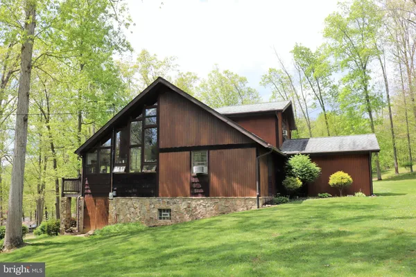 a view of a house with a yard and a large tree