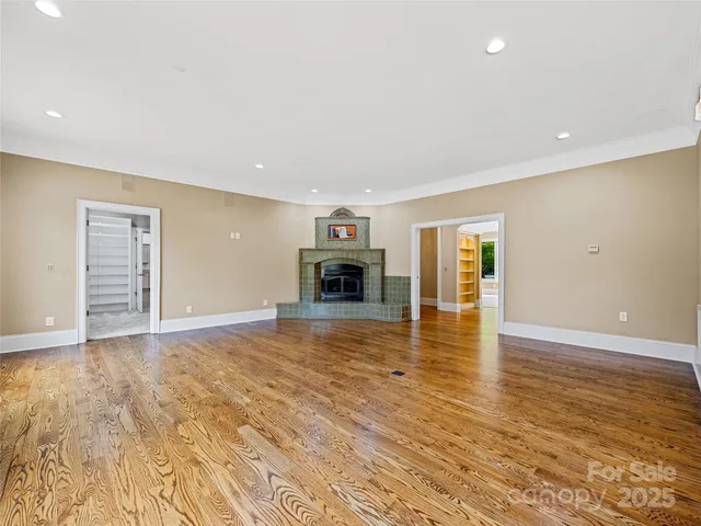 an empty room with wooden floor and fireplace