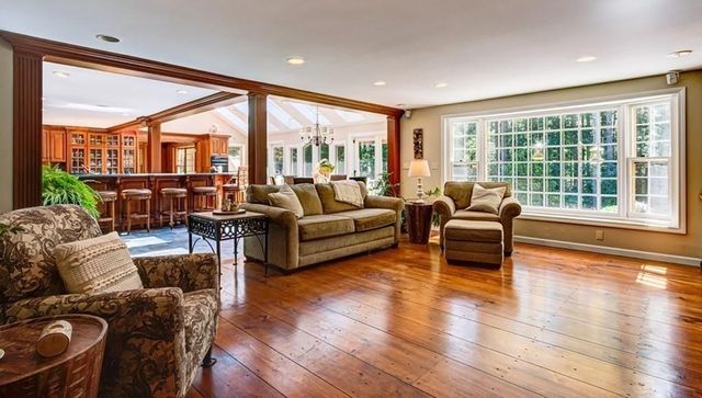 a living room with furniture and a large window with wooden floor