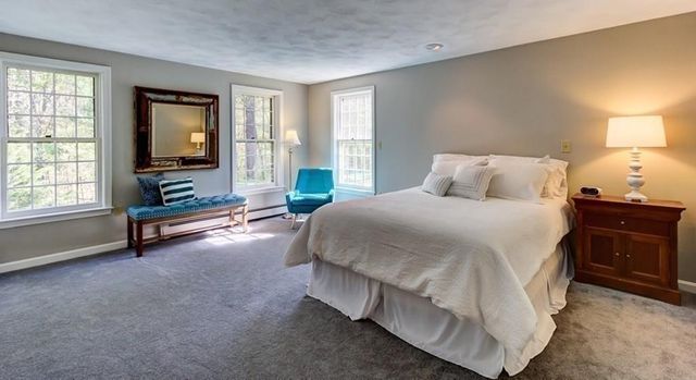 a spacious bedroom with a bed and wooden floor