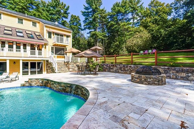 a view of a house with swimming pool and sitting area