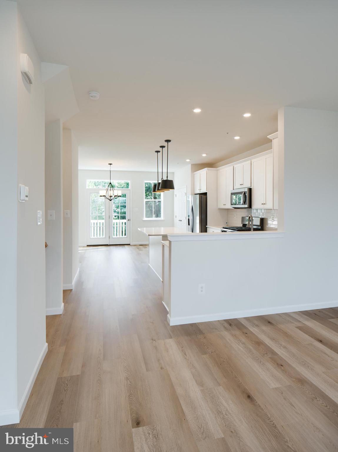 2609 Front Shed Drive Frederick, MD 21702 - Photo 27 of 78 a kitchen with stainless steel appliances granite countertop a refrigerator a sink dishwasher a stove and white countertops with wooden floor