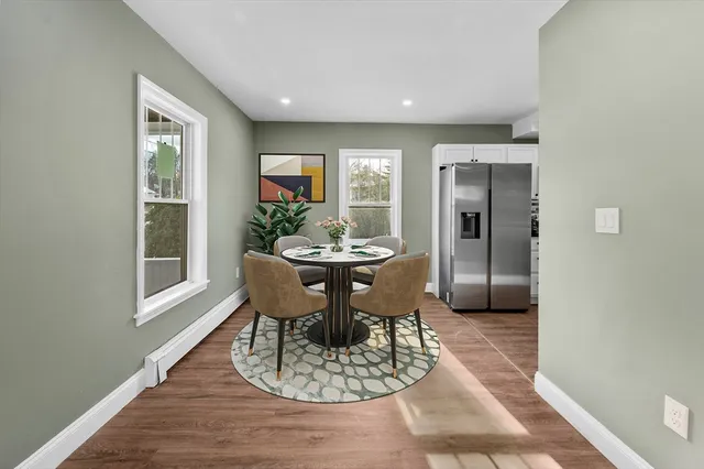 a dining room with furniture a window and wooden floor