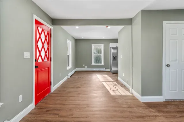 a view of a hallway with wooden floor and stairs