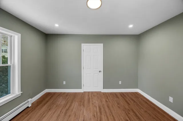a view of room with window and wooden floor