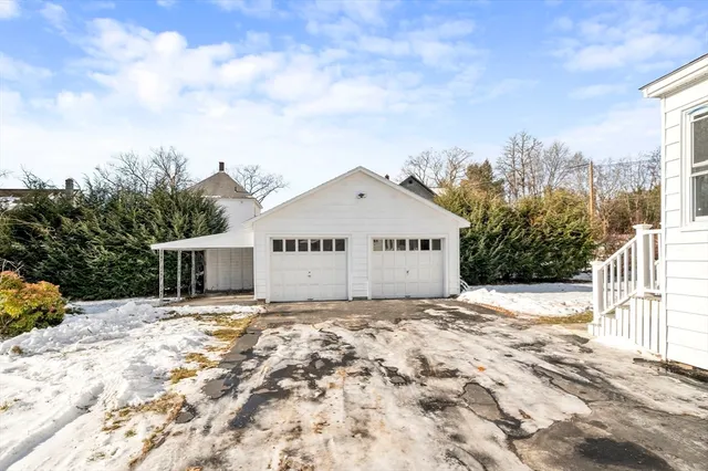 a view of a white house with a large tree and a yard