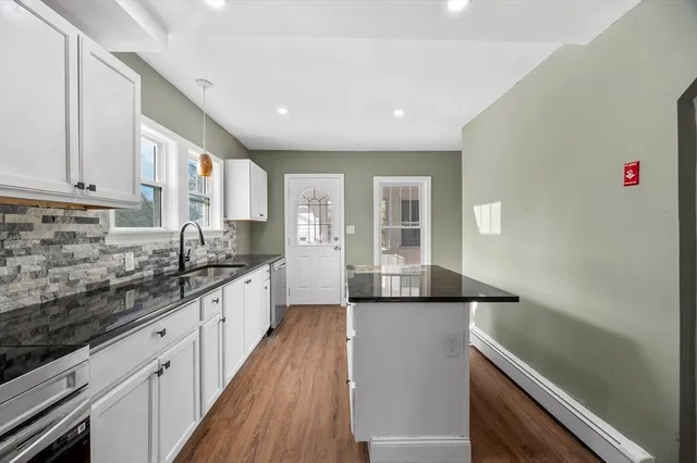 a kitchen with granite countertop a sink and cabinets