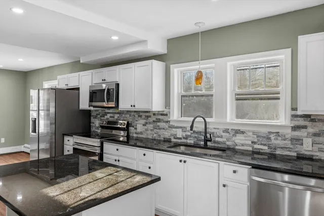 a kitchen with stainless steel appliances granite countertop a sink stove and refrigerator