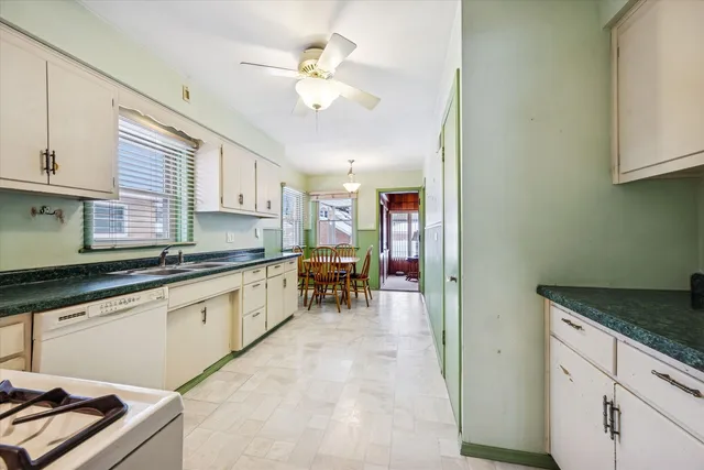 a kitchen with granite countertop white cabinets and white appliances