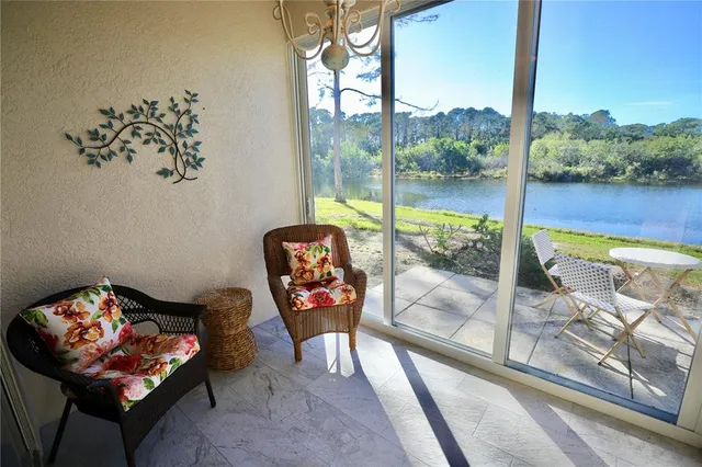 a living room with furniture and a floor to ceiling window