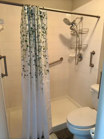 a bathroom with a shower a toilet and a shower