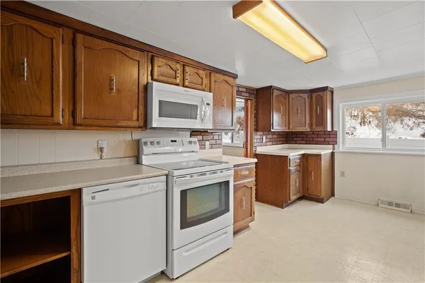 a kitchen with granite countertop a refrigerator and a stove top oven