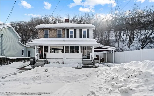 a view of a house with a yard covered in snow