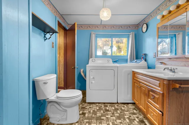 a bathroom with a sink toilet vanity and window