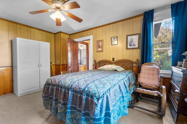 a bedroom with a bed next to a window