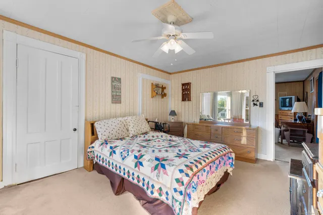 a bedroom with a large bed chandelier and a window