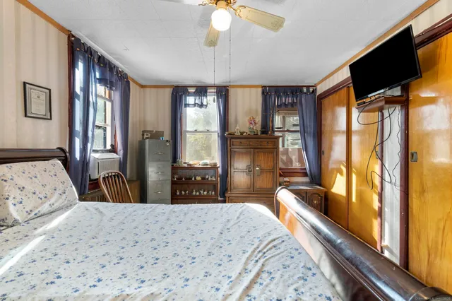 a bedroom with a large bed and a flat tv screen