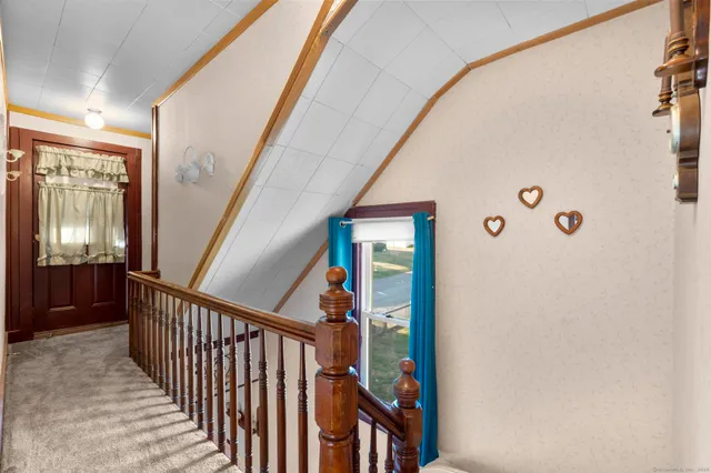 a view of a hallway with wooden floor and windows