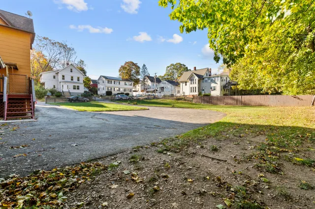 a view of a houses with a yard and a large tree