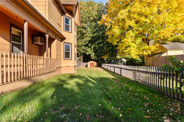 a view of a house with a small yard and wooden fence