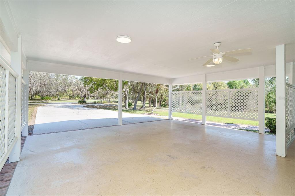 9299 Southwest Lipe Road Arcadia, FL 34269 - Photo 42 of 68 an empty room with floor to ceiling windows and a flat screen tv