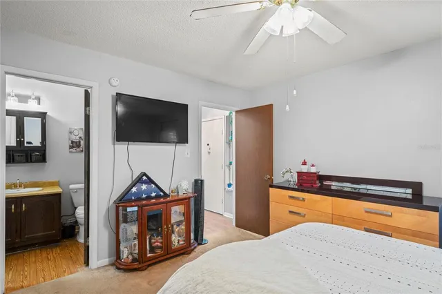 a bedroom with a bed and a flat tv screen on wall
