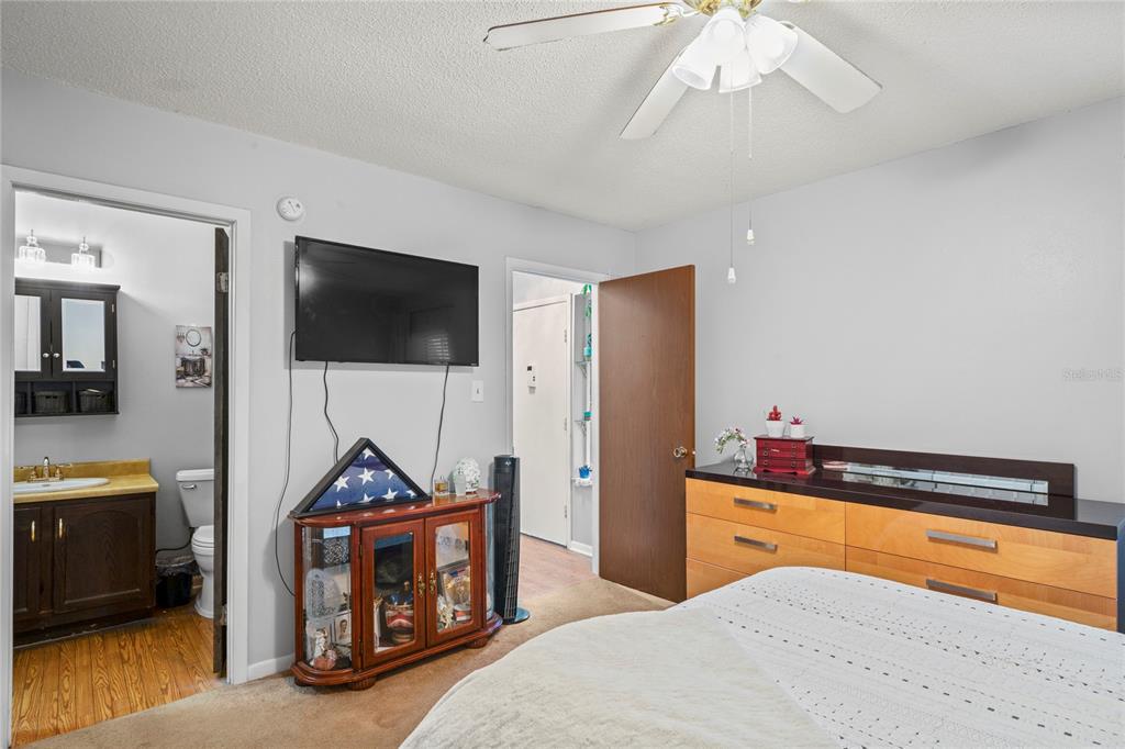 802 Antler Court Brandon, FL 33511 - Photo 13 of 37 a bedroom with a bed and a flat tv screen on wall
