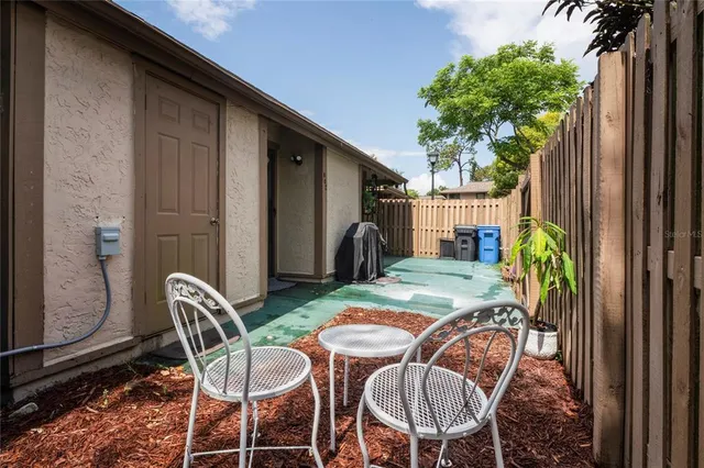 a backyard of a house with barbeque oven table and chairs