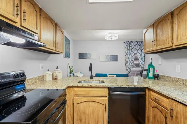 a kitchen with stainless steel appliances granite countertop a sink stove and cabinets