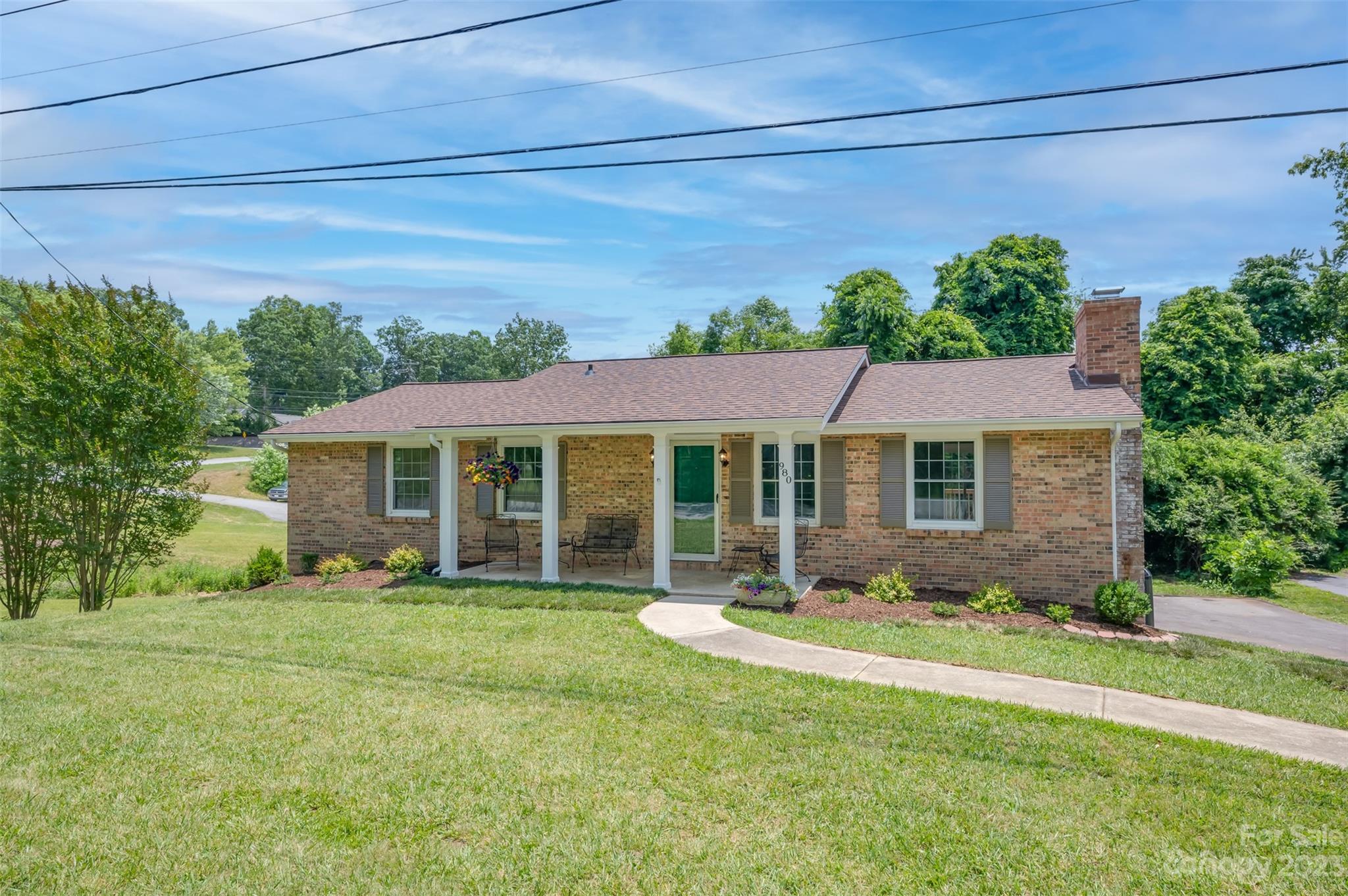980 Brookside Camp Road Hendersonville, NC 28792 - Photo 1 of 47 a front view of a house with garden